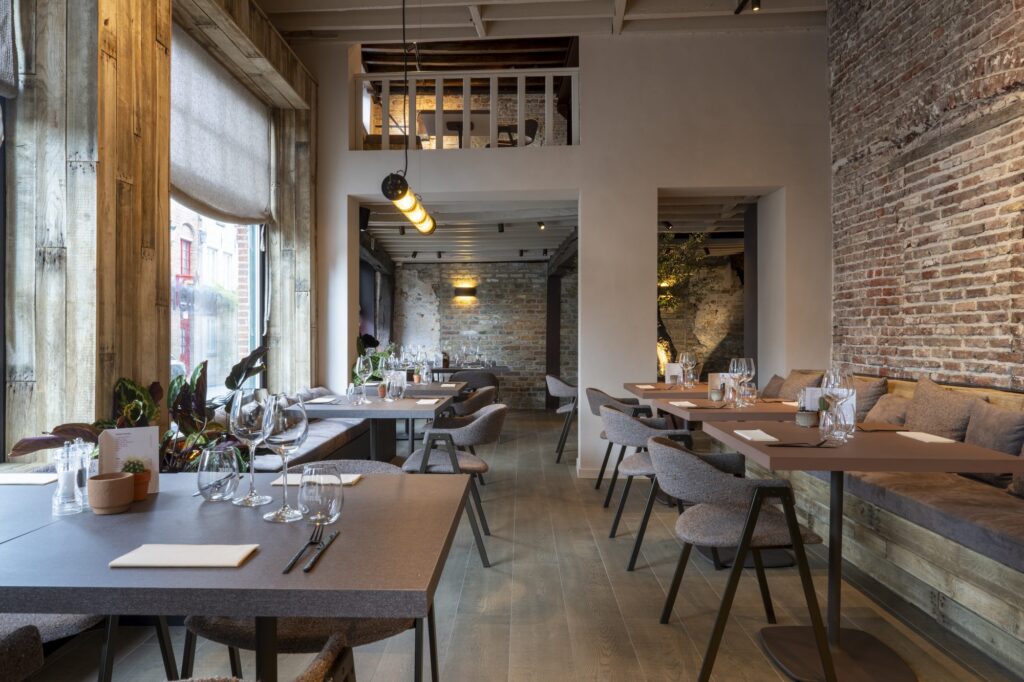Restaurantzaal met baksteen muur en zitbank