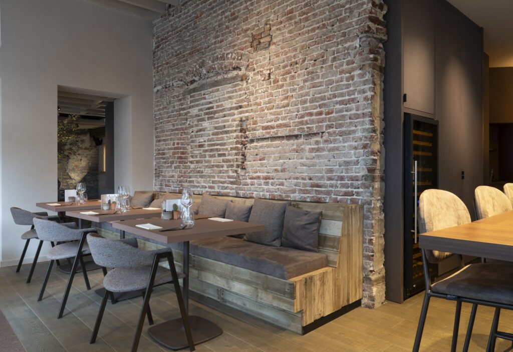 Restaurantzaal met gedekte tafels en zitbank